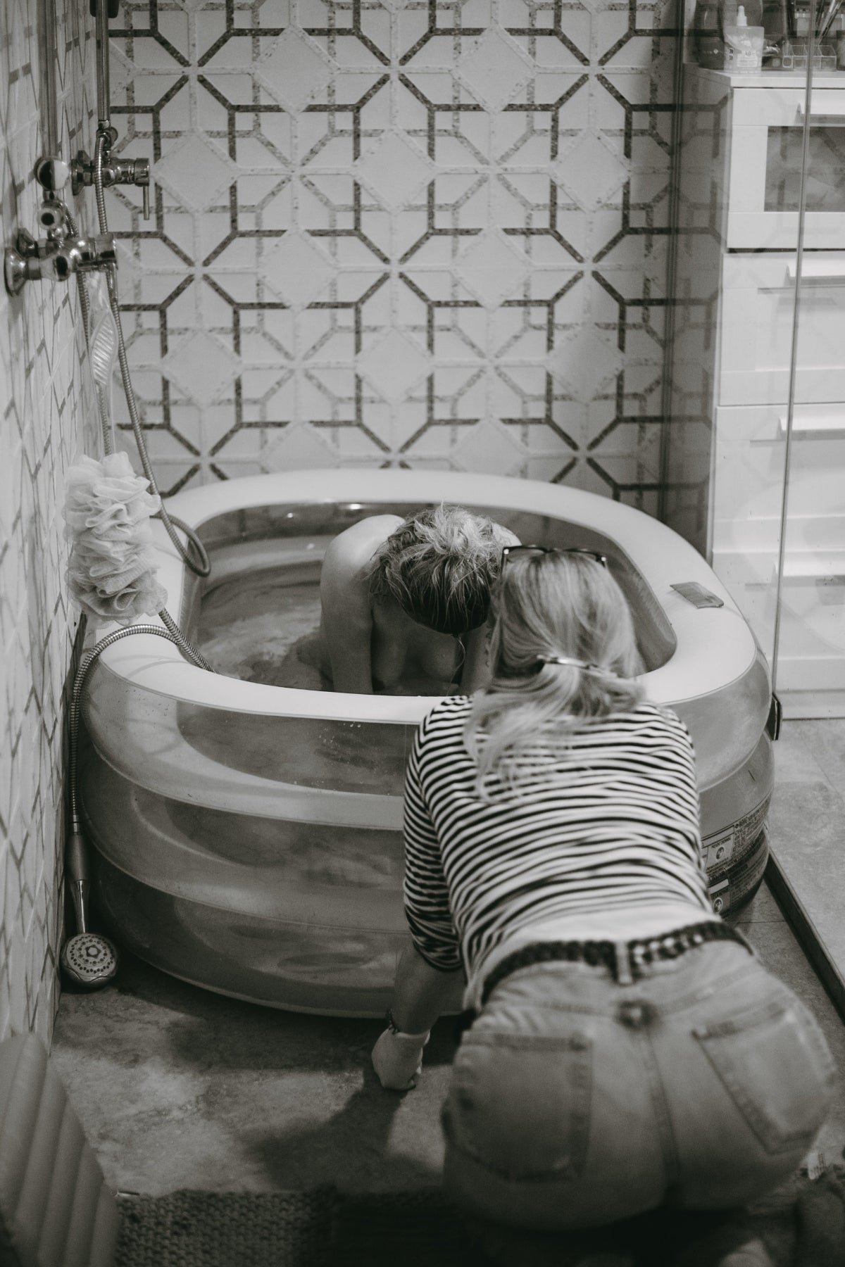 Schwarzweißes Foto einer Wassergeburt mit Doula-Unterstützung – SULIA Doula Ausbildung